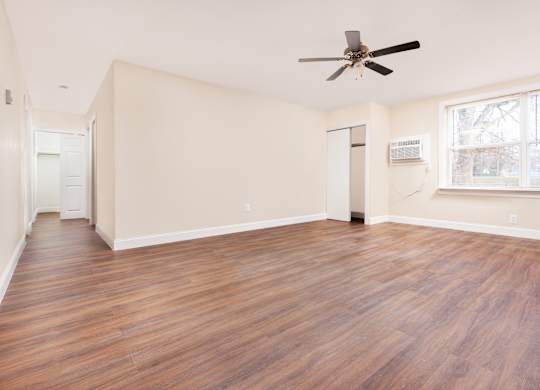 A room with wooden floors and a ceiling fan.