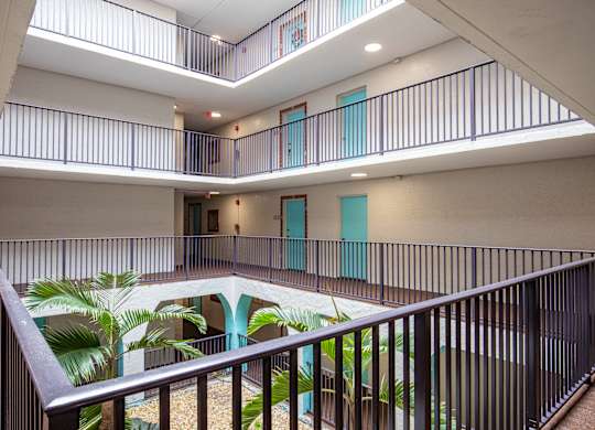 A balcony with a metal railing and a pool in the middle of the room.