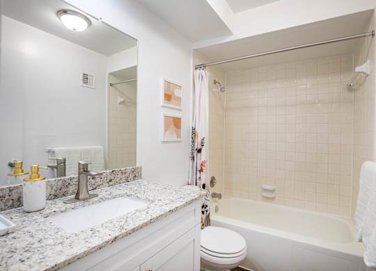 A white bathroom with a sink, toilet, and bathtub.