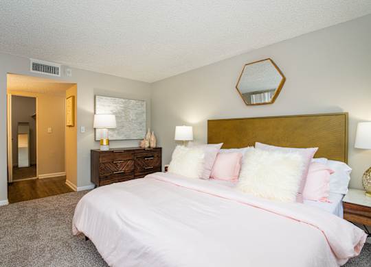 A bedroom with a bed, nightstand, and lamp.