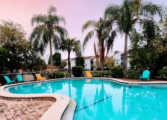a large pool with palm trees and chairs around it at Sunscape Apartment Homes, Tampa, FL, 33613