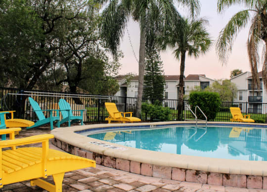 our apartments have a large swimming pool with yellow and blue chairs at Sunscape Apartment Homes, Tampa, Florida