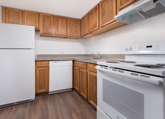 A white refrigerator is in a kitchen with wooden cabinets.