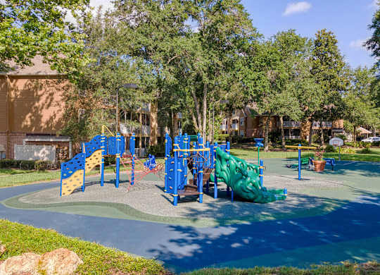 A playground with a blue slide and a green slide.