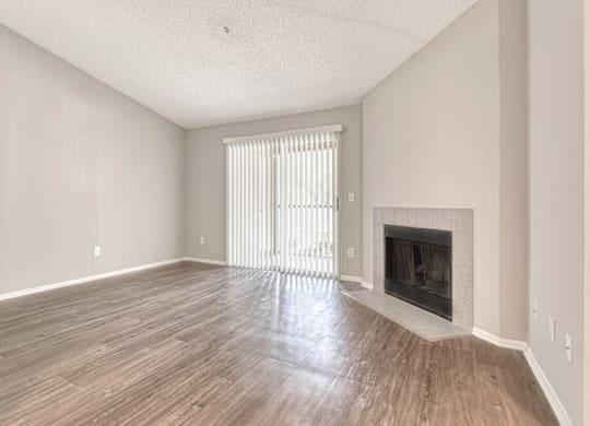 A room with a fireplace and a window with blinds.