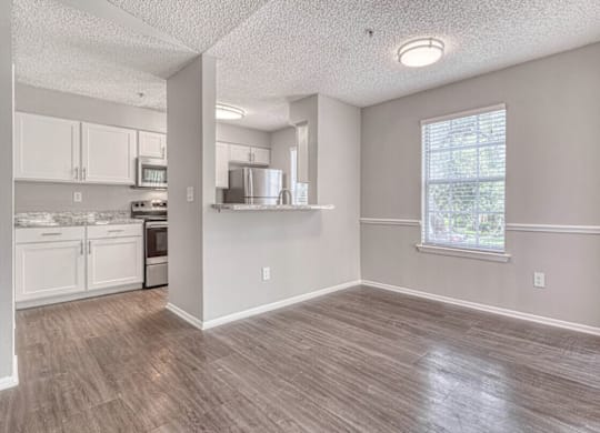 A kitchen with white cabinets and a window.