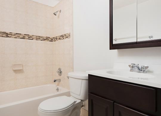A white toilet sits next to a bathtub in a bathroom.