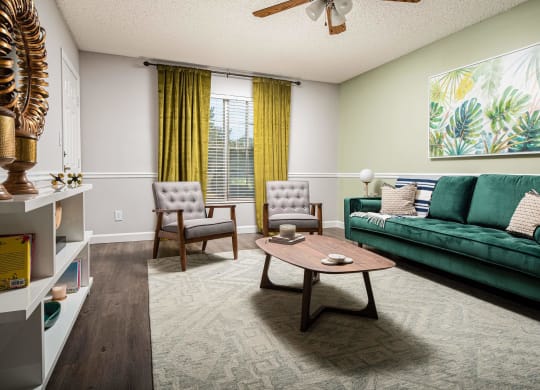 a living room with a green couch and a coffee table  at The Park at Chesterfield Apartment Homes, Tampa, Florida