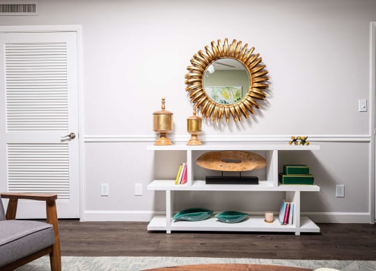 a living room with a mirror and a white shelf  at The Park at Chesterfield Apartment Homes, Tampa, FL, 33617