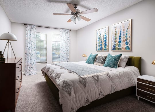 a bedroom with a bed and a ceiling fan  at The Park at Chesterfield Apartment Homes, Florida