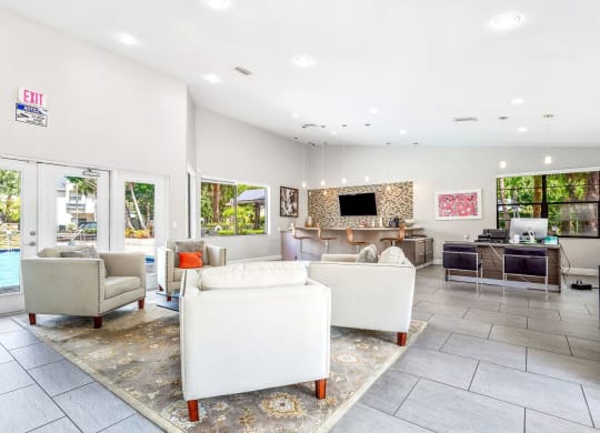 a living room with couches and chairs and a pool at Waterford Park Apartment Homes, LLC, Lauderhill