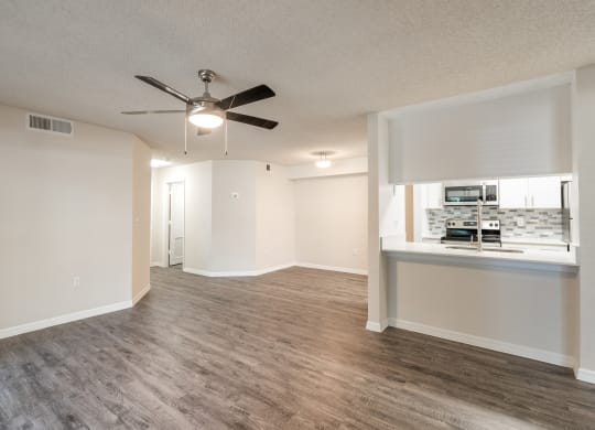 an empty living room with a ceiling fan and a kitchen  at Fisherman's Landing Apartment Homes, Tampa, FL, 33637