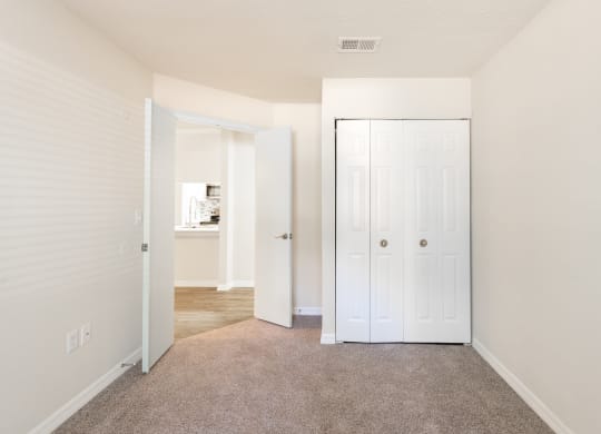 a bedroom with a closet and a door to a bathroom  at Fisherman's Landing Apartment Homes, Florida
