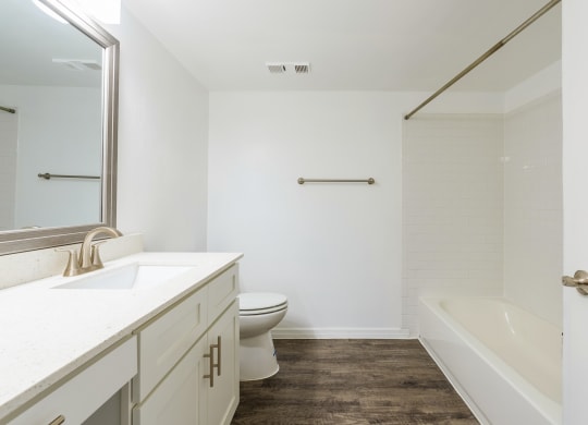 a bathroom with a toilet and a tub and a sink  at Fisherman's Landing Apartment Homes, Tampa, Florida
