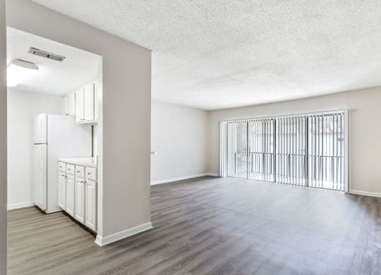 an empty living room and kitchen with a large window at Greenwich Commons Apartment Homes, Tampa, 33613