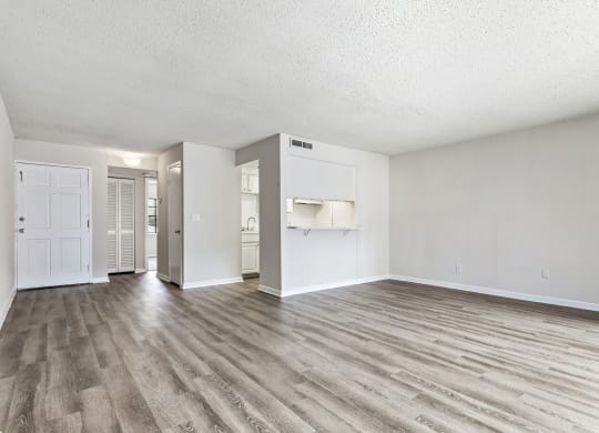 an empty living room with white walls and wood flooring at Greenwich Commons Apartment Homes, Florida