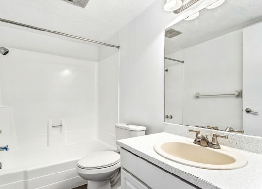 a white bathroom with a sink and a toilet at Greenwich Commons Apartment Homes, Florida
