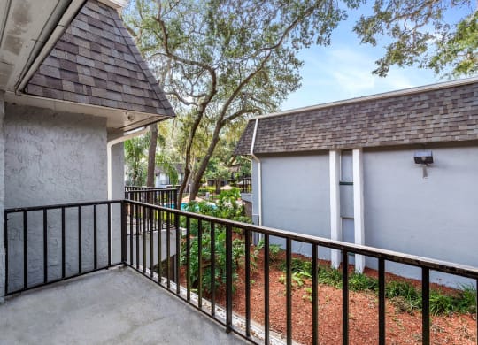 a balcony with a white house and a tree at Greenwich Commons Apartment Homes, Florida, 33613