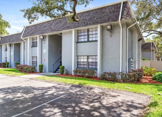 a white house with a sidewalk in front of it at Greenwich Commons Apartment Homes, Florida, 33613