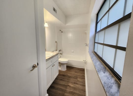 an empty bathroom with a toilet and a sink at Greenwich Commons Apartment Homes, Tampa