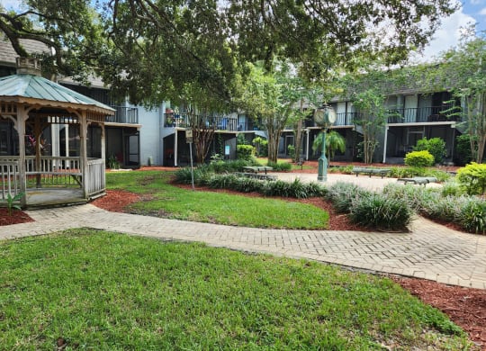 a gazebo in the middle of a yard in front of a building at Greenwich Commons Apartment Homes, Tampa, FL, 33613