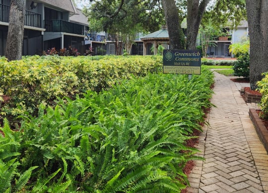 a sidewalk in front of a building with a sign at Greenwich Commons Apartment Homes, Florida, 33613