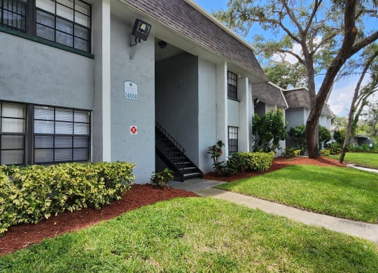 the front of a house with a walkway and grass at Greenwich Commons Apartment Homes, Tampa