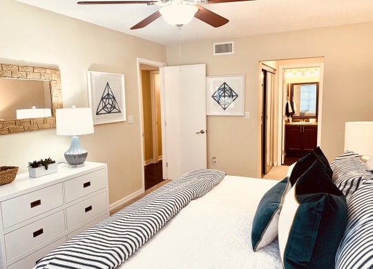 a bedroom with a large bed and a ceiling fan at Madison Oaks Apartment Homes, LLC, Palm Harbor, FL 34684