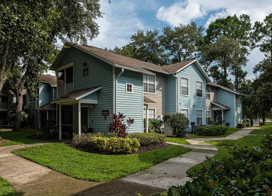 a blue house with a sidewalk in front of it at Madison Oaks Apartment Homes, LLC, Florida, 34684