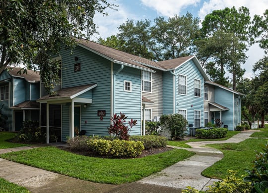 a blue house with a sidewalk in front of it at Madison Oaks Apartment Homes, LLC, Palm Harbor, 34684