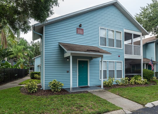 the front of a blue house with a green door at Madison Oaks Apartment Homes, LLC, Palm Harbor Florida