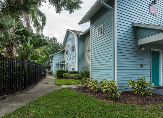 a blue house with a sidewalk in front of it at Madison Oaks Apartment Homes, LLC, Florida