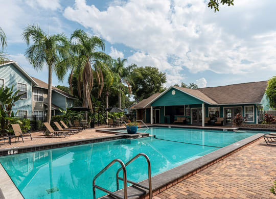 a swimming pool with a house in the background at Madison Oaks Apartment Homes, LLC, Palm Harbor
