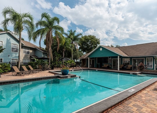 a large swimming pool with a house in the background at Madison Oaks Apartment Homes, LLC, Palm Harbor