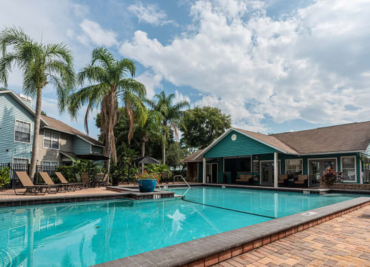 a large swimming pool with a house in the background at Madison Oaks Apartment Homes, LLC, Palm Harbor, FL 34684