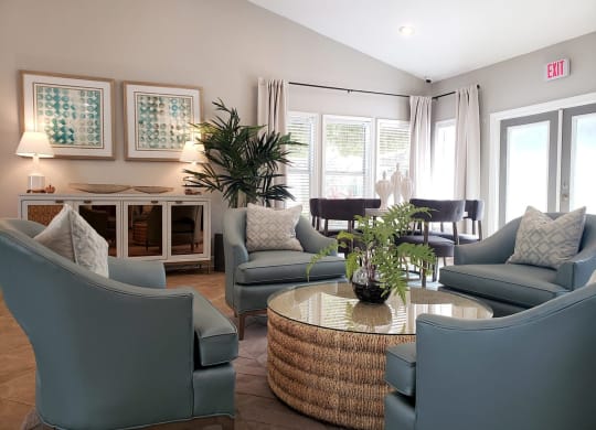 a living room with blue chairs and a table at Madison Oaks Apartment Homes, LLC, Palm Harbor, FL
