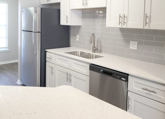 a kitchen with white cabinets and a stainless steel refrigerator at Madison Oaks Apartment Homes, LLC, Palm Harbor, FL