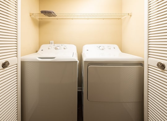 a small laundry room with two washes and a dryer at Madison Oaks Apartment Homes, LLC, Florida