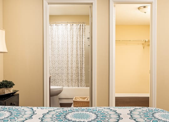 a bedroom door open to a bathroom with a toilet and a shower at Madison Oaks Apartment Homes, LLC, Palm Harbor, 34684