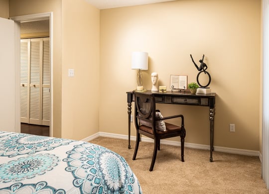 a bedroom with a desk and a door to a closet at Madison Oaks Apartment Homes, LLC, Palm Harbor, FL