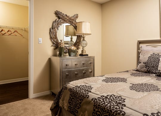 a bedroom with a bed and a dresser with a mirror at Madison Oaks Apartment Homes, LLC, Palm Harbor Florida