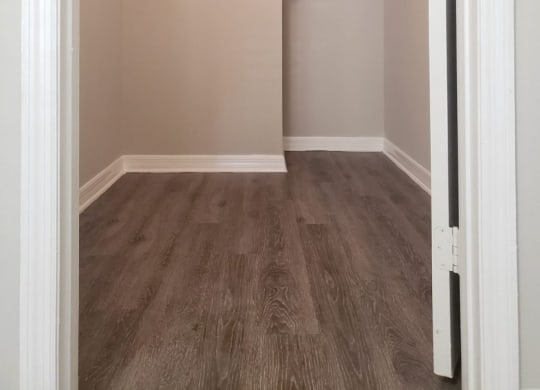 a spacious closet with shelves and a wood floor in an empty room at Madison Oaks Apartment Homes, LLC, Florida