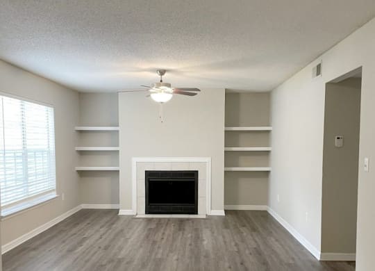 an empty living room with a fireplace and shelves at Madison Oaks Apartment Homes, LLC, Florida