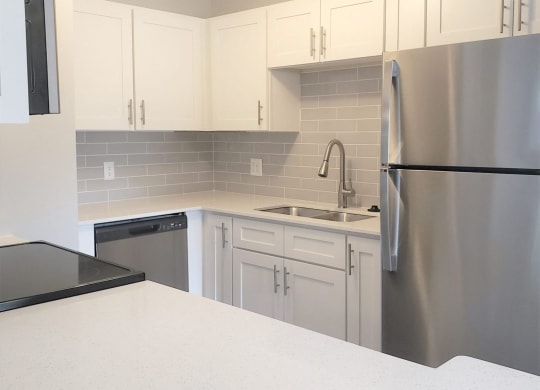a kitchen with a white counter top and a stainless steel refrigerator at Madison Oaks Apartment Homes, LLC, Palm Harbor Florida