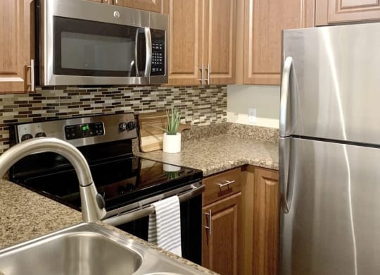 a kitchen with stainless steel appliances and granite counter tops at Madison Oaks Apartment Homes, LLC, Florida, 34684