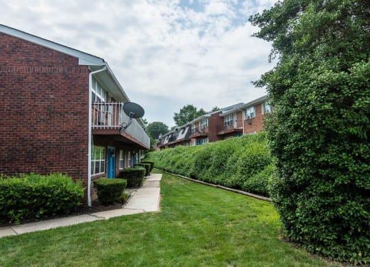 a row of brick apartment buildings with grass and bushes at Raritan Crossing Apartment Homes, New Jersey