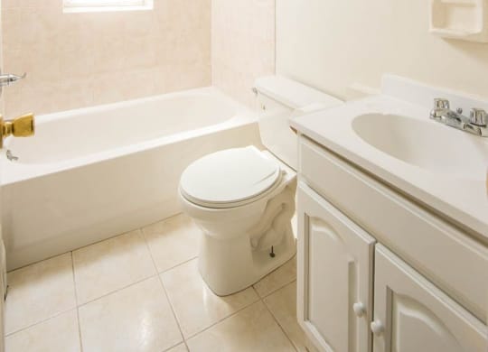 a bathroom with a toilet and a sink and a bath tub at Raritan Crossing Apartment Homes, New Brunswick, 08901