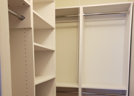 a walk in closet with white shelves and at Raritan Crossing Apartment Homes, New Brunswick, NJ 