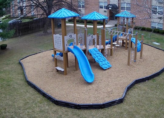 a playground with a blue slide and playset in a yard at Aspen Grove Apartment Homes, Warminster, PA 18974