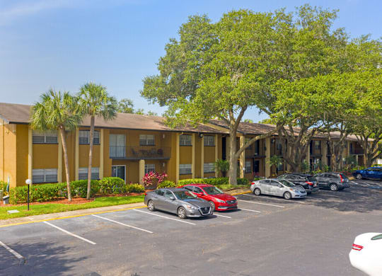 A parking lot with cars and a building in the background.